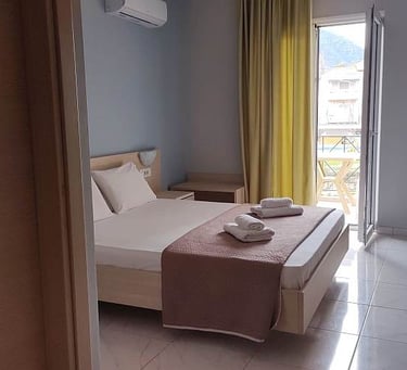 Delfini hotel bedroom with a bed and a balcony