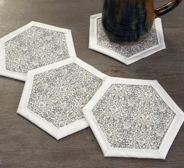 a mug of coffee on hexagon shaped fabric coasters