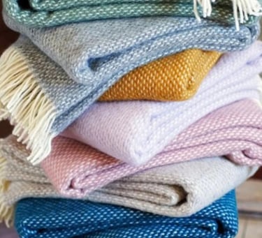 a stack of soft, colourful woollen blankets
