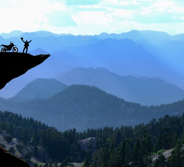 Motorcycle Rider on dangerous cliff feeling triumphant after GJ Silver Ride to Rise Coaching