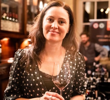 Woman with long brown hair holding a glass of red wine