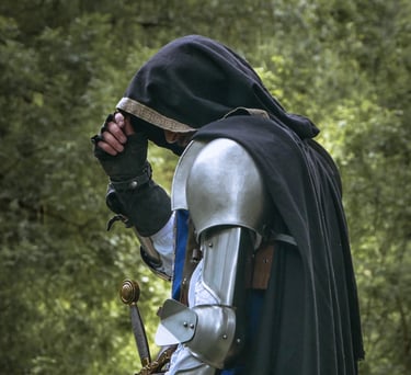 Homme mystérieux en armure et cape sur un fond de feuilles verdoyante. C'est peut-être un rôdeur