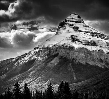 Charity Mountain in the Canadian Rocky Mountains, showcasing it's rugged snow covering and a dramtic sky