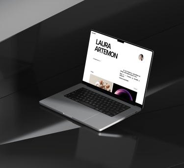 A laptop computer on a desk displaying the Laura.art website.