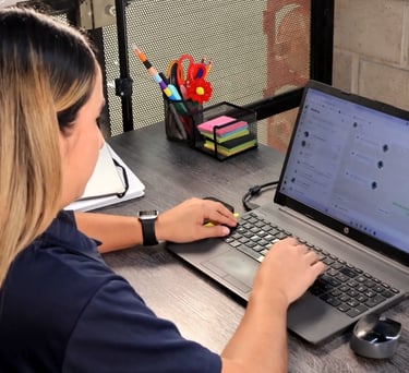 a woman sitting at a desk with a laptop computer