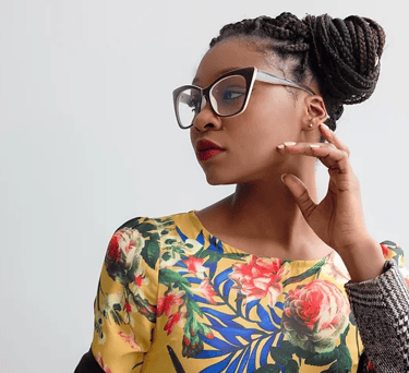 African-American woman with floral print top and hair pulled in a braided bun