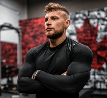 a man with a beard and a beard, standing in a gym