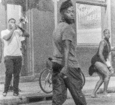 a man walking down the street with a bicycle