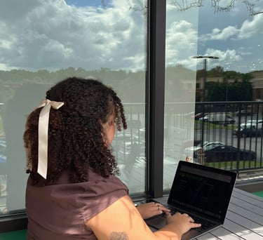 a woman sitting at a table with a laptop