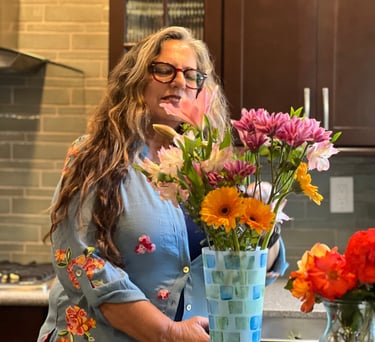 a woman standing in front of a vase with flowers