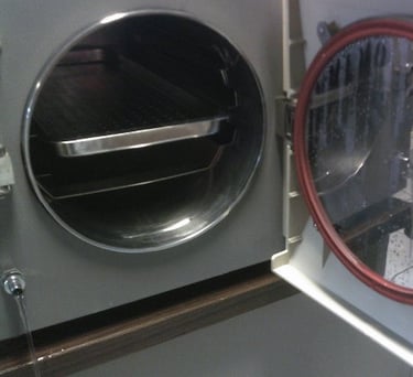 esterilizador de vapor con puerta abierta y charola de acero inoxidable