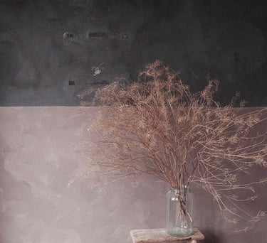 a vase with dried twigs in a vase on a wooden table