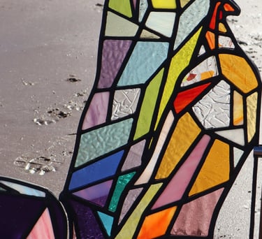 Full Sized Stained Glass Woman. Photograph is taken on a beach at low tide. Art work by Laura Kriefman