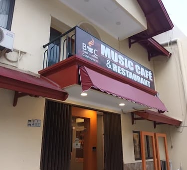 a building with a red awning and a sign that says music cafe