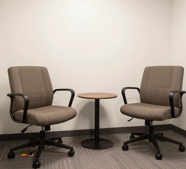 A clean, bright photograph of a modern North American consultation room with two comfortable chairs and a small table, designed to feel safe and private.