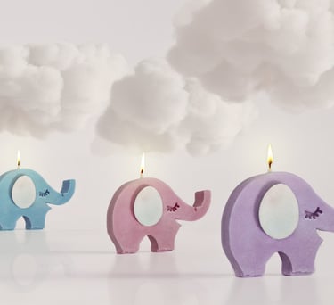 Velas con forma de elefante, de color azul, rosa y morado, iluminadas con un toque de fantasía