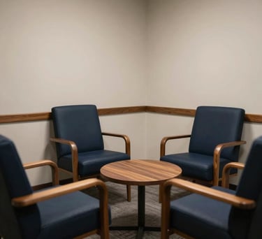 A comfortable, private North American consultation room with deep navy chairs and warm wood accents, designed for confidential conversations.
