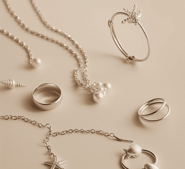 Colección vertical de joyería de acero inoxidable plateada con dijes de estrella de mar, conchas y p