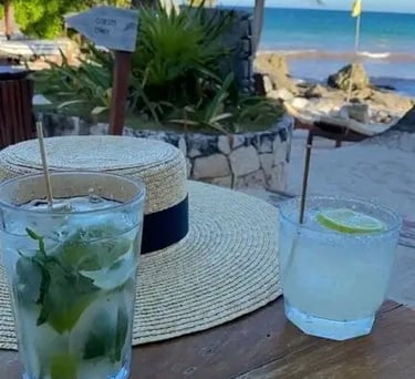two glasses of water and a straw hat on a table