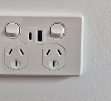White double power point with USB-A and USB-C ports on a modern white wall.