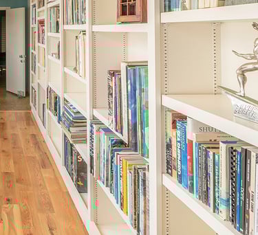 a long narrow hallway with a long shelf of books