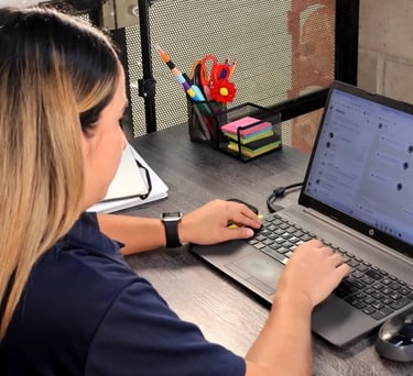 a woman sitting at a desk with a laptop computer