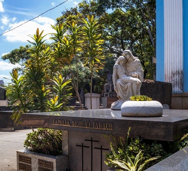 A imagem mostra uma estátua de uma estátua de uma mulher sentada em um jazigo