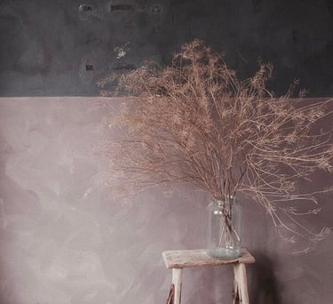 a vase with dried twigs in a vase on a wooden table