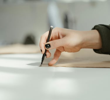 a person holding a pen and writing on a paper