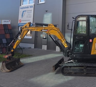 Pfalz-Hub Minibagger SANY SY26U auf dem Betriebsgelände von Holztechnik Volk vor der Werkstatt