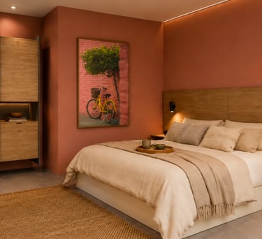 Modern bedroom with terracotta walls, wooden headboard, and minimalist desk area.