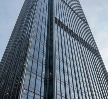 A sleek, low-angle photograph of a modern glass skyscraper in a North American business district, representing the strength and authority of the Foundation.