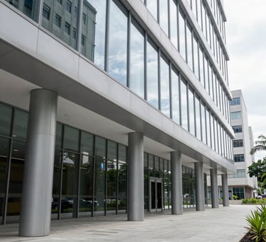 A clean, bright corridor in a corporate Brazilian legal building. Modern architecture with floor-to-ceiling glass and light gray steel elements. Sophisticated and transparent.