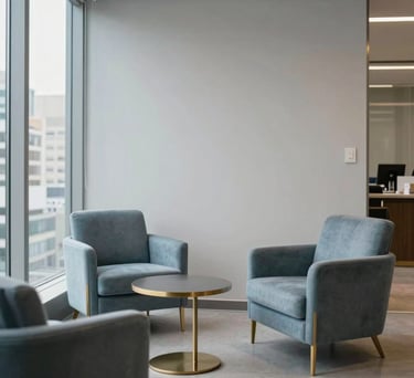 A quiet lounge area for clients in a Brazilian law firm. Neutral light gray tones with gold details, comfortable slate blue armchairs, and a view of urban architecture.