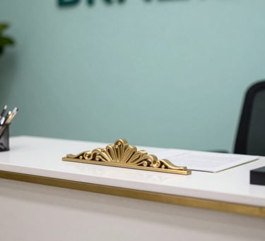 A detail shot of a reception area in a Brazilian health association. A gold-toned decorative element is visible on a clean white desk, with a soft teal backdrop.