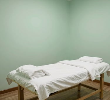 Photography of a serene acupuncture treatment room in a Southeast Asian clinic, featuring a clean massage bed, soft lighting, and a peaceful atmosphere with pastel green walls.