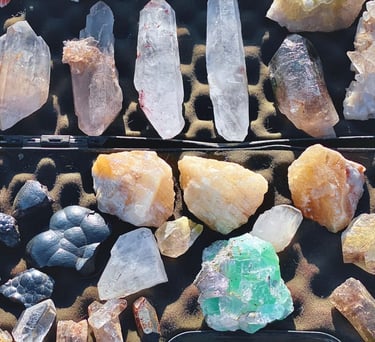 Colección de cristales y minerales en bruto que incluye puntas de cuarzo transparente, amatista.