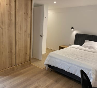 Moderna habitacion, con velador y luz de pared, en hotel hospedaje condor palace en huayllay pasco
