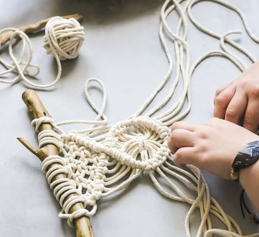 Tejido en macramé blanco sobre una mesa gris