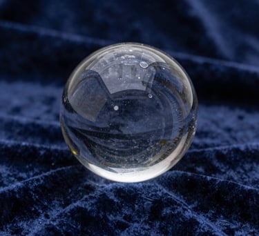 A mystical photograph of a crystal ball reflecting a Northern European starlit sky, placed on a deep navy velvet cloth. The image is sharp, professional, and evokes a sense of extrasensory perception and mystery.