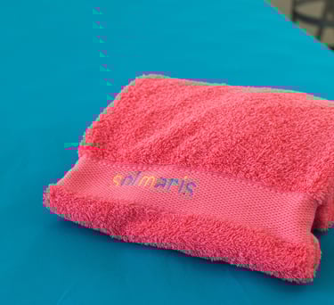 a towel towel on a table with a pink towel