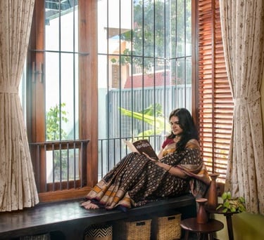 a woman sitting on a bench in a window