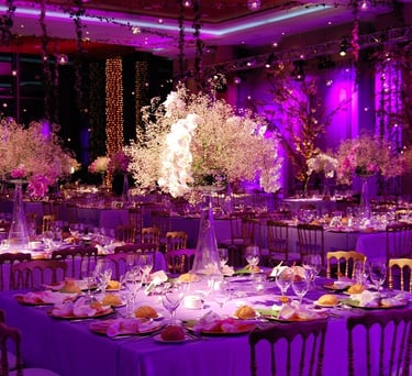 Salón decorado con luces rosas, mesas elegantes y ambiente sofisticado para eventos.
