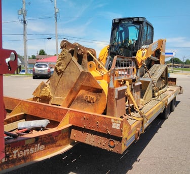 a tractor trailer with a loader on it