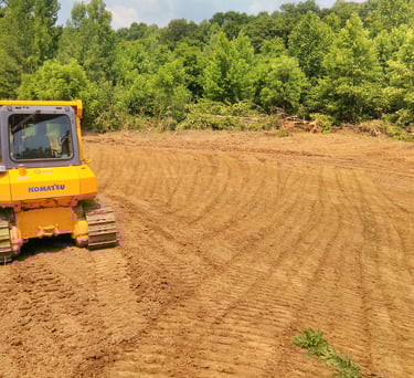 a tractor with a bulldozer in the middle of a field