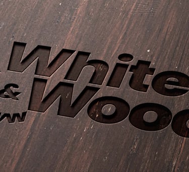 Engraved logo on wood surface of White and Wood Custom Carpentry
