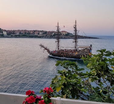 a boat sailing in the ocean at sunset