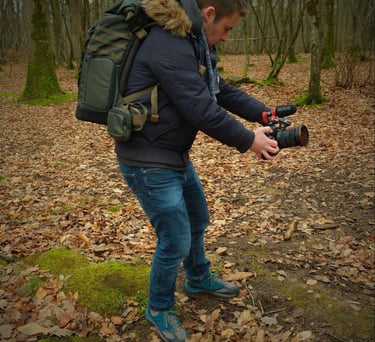 a man in a blue jacket and jeans is taking a picture of a camera