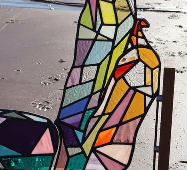 Full Sized Stained Glass Woman. Photograph is taken on a beach at low tide. Art work by Laura Kriefman