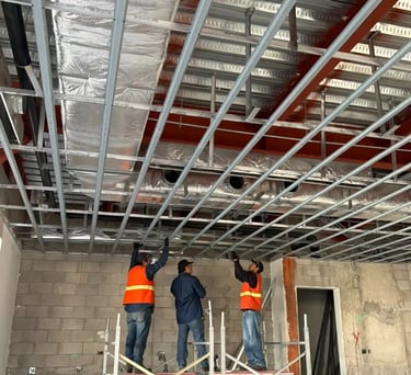 Trabajadores HVAC sobre andamios instalando ductería residencial